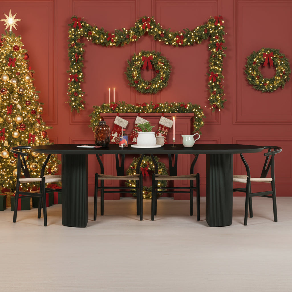 Dining room with a black oval table and chairs, featuring decorative items and a wall art piece.