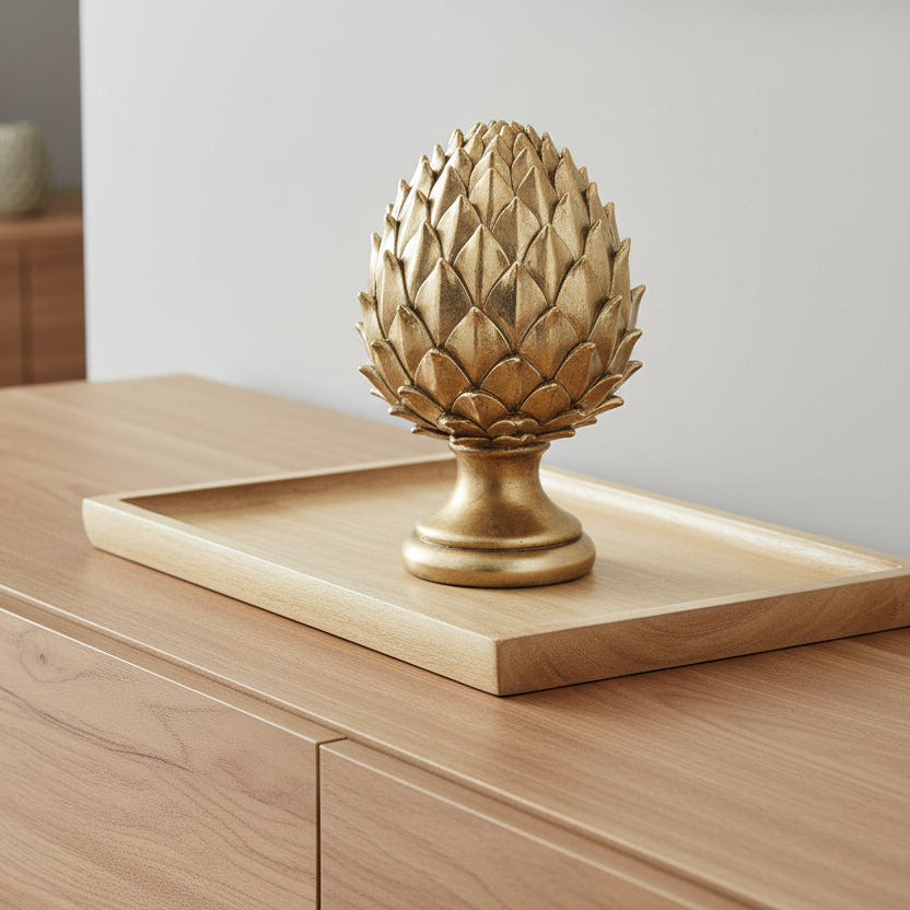 Decorative gold Pinecone-shaped object on a white background